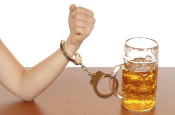 Рука прикованная наручниками к кружке пива